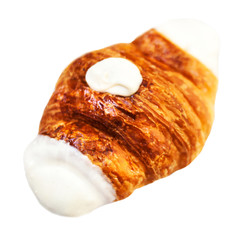 Fresh croissant decorated  with white chocolate isolated on a white background closeup