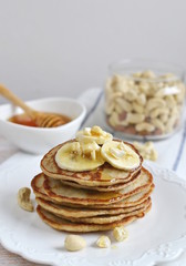Homemade Banana Cashew Pancakes Honey Sauce Milk Flour Wooden Table Kitchen Towel Cutlery 
