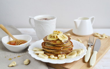 Homemade Banana Cashew Pancakes Honey Sauce Milk Flour Wooden Table Kitchen Towel Cutlery 