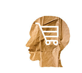 Crumpled paper shaped as a human head and shopping cart on white.
