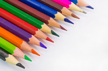 Color pencils in rainbow on white background