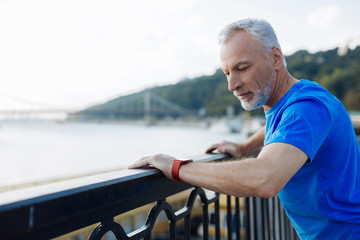 Pleasant senior man checking time on bridge