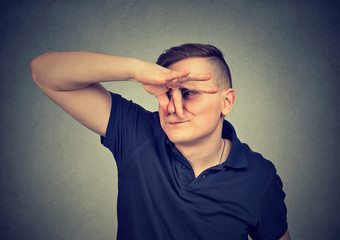 man pinches nose with fingers looks with disgust something stinks