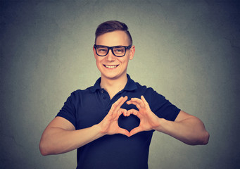 happy handsome man in glasses making heart with fingers.