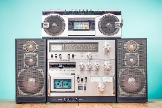 Retro outdated HI FI stereo boom box system and radio cassette tape recorder from 80s front mint green background. Vintage instagram old style filtered photo