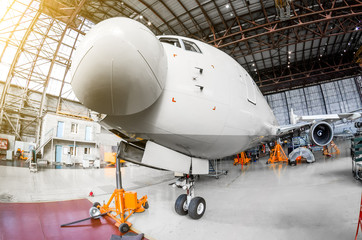 Airliner aircraft in a hangar with on jack stands