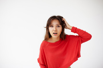 Fototapeta premium Headshot portrait of ingenious young woman in red sweater holding hand on nape remembered something important. Body language, facial expressions and emotions