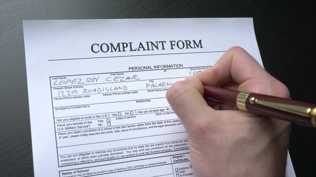 Complaint form being filled closeup. This form is randomly filled with no real names or numbers.