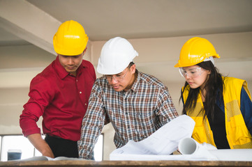 Engineer and foreman discuss on site and check blueprint