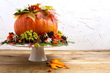Thanksgiving table centerpiece with pumpkin, seeds and cones, copy space.