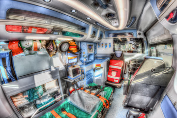 Inside the ambulance, view from the sanitary compartment. Different medical equipment and a stretcher. Selective focus, high key.