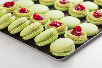 Green macaroons with pistachios ganache cream and raspberries confit filling