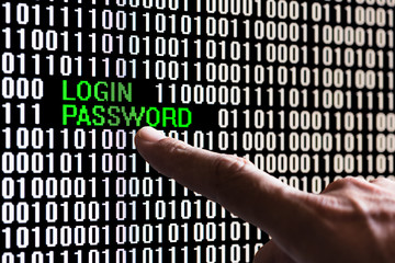 Finger pointing login password in binary code on a computer screen