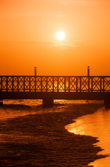 Fototapeta premium Sunset over the sea. Pier on the foreground. Panorama
