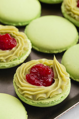 Green macaroons with pistachios ganache cream and raspberries confit filling