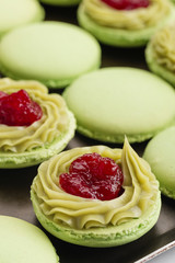 Green macaroons with pistachios ganache cream and raspberries confit filling