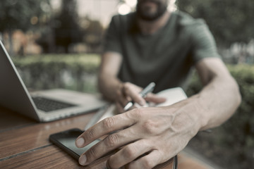 Close-up. A young man takes the phone from the table