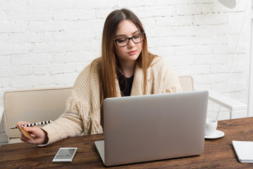 Young woman in glasses online shopping at home