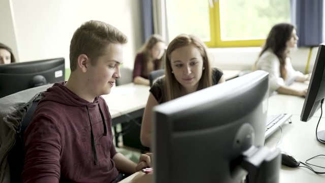 Junge und M&auml;dchen lernen gemeinsam im Klassenzimmer Computerraum
