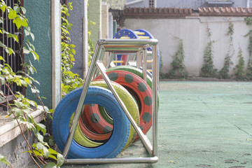 Colorful tires. School field playground. Green artificial grass field, reused rubber wheel...