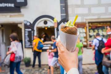 Popular traditional sweet from Czech Republic call as Trdelnik made from rolled dough wrapped around the stick then grilled and topped with walnut and sugar, serve with Vanilla ice cream