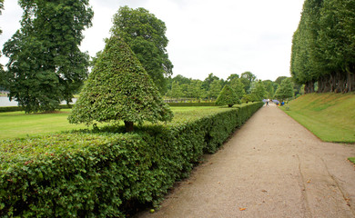 Walk way in beautiful baroque-style Frederiksborg Castle Gardens, renaissance king residence, cloudy weather, Hillerod, Denmark