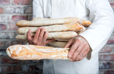 baker holding  traditional bread french baguettes