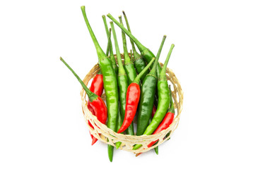Chili pepper. Lots of pepper, red and green are in the little basket woven from bamb