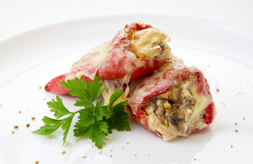 Stuffed Red bell peppers with mushrooms on the white plate.