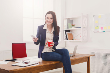 Business woman sitting on workplace with cup