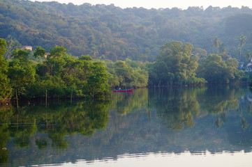 Fototapeta na wymiar Boat on the river. Trees are reflected in water.