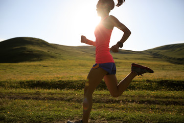 young fitness woman runner running on sunset trail