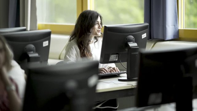 Sch&uuml;lerin schreibt auf Tastatur und redet und kaut Kaugummi