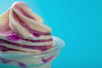 cup of strawberry flavor ice cream on blue background with copy space