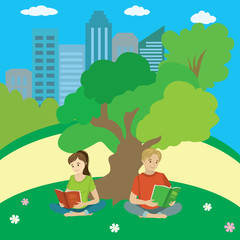 Teenagers sit on the grass in the park and read