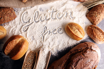 gluten free breads, glutenfree word written and bread rolls on grey background