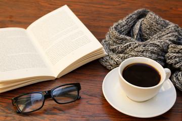 coffee scarf book and glasses on wooden table