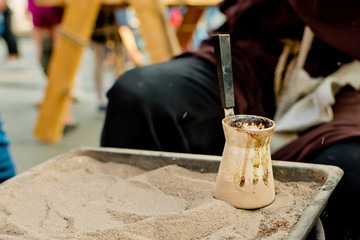 Close up view of turkish coffee prepared on hot golden sand.