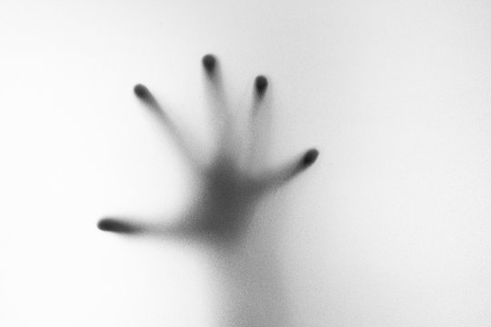 Shadow of hand the white frosted glass
