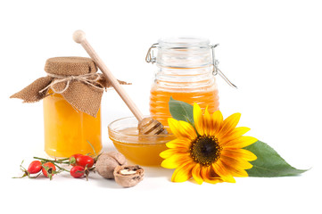 Natural honey in jar with sunflower, walnuts on a white background