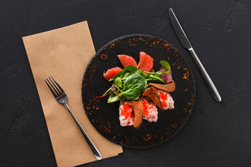 Gourmet seafood snack on black plate top view