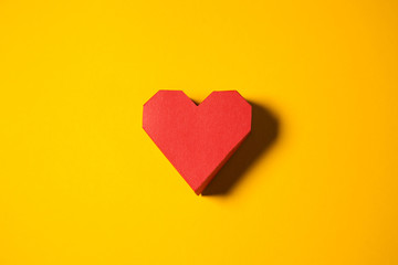 Red paper heart on a yellow background