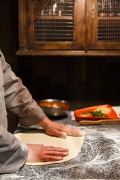 Hands kneading dough for pizza making