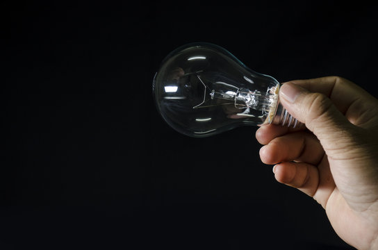 bulb light in human hand and black background
