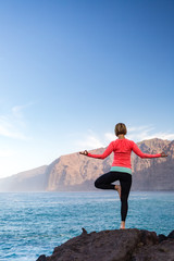 Woman meditating in yoga vrksasana tree pose