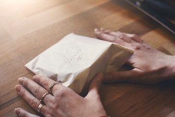 Obraz premium Female shop assistant wrapping a piece of cheese