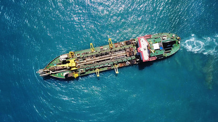 Suction Dredger ship working near the port - with mud, Pollution, brown Muddy water - aerial tip down shot