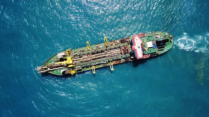 Suction Dredger ship working near the port - with mud, Pollution, brown Muddy water - aerial tip...