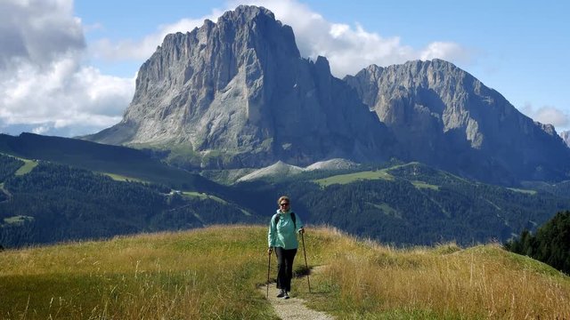 Hiker hiking in beautiful landscape agains a backdrop of mountain peak