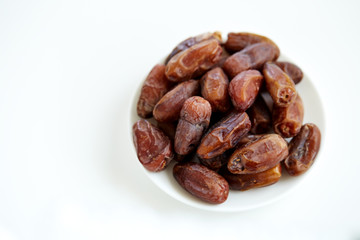 Bowl of dried dates isolated on white backgroun